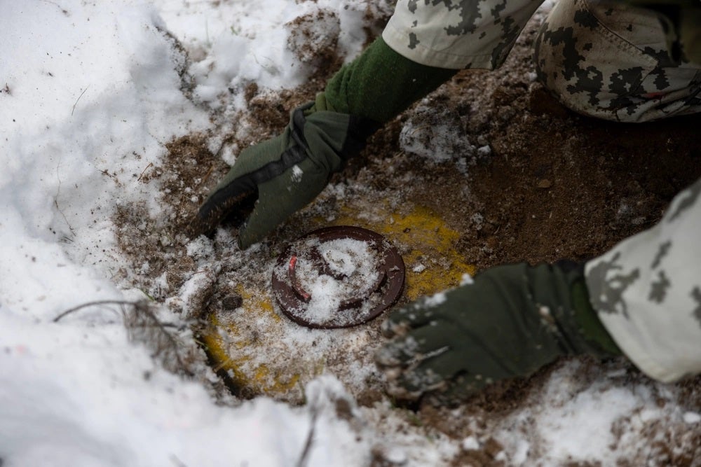 A Finnish Service Member with the Nylands Brigade, Finnish Navy, buries a mine during exercise Freezing Winds 23 (FW23) in Syndalen, Finland, Nov. 28, 2023. FW23 is a Finnish-led maritime exercise in which United States Marines assigned to Marine Rotational Force- Europe, and U.S. Navy Forces Europe take part; the exercise serves as a venue to increase Finnish Navy readiness, increase U.S., Finland, and NATO partners' interoperability in operational logistics, integrated fires, and amphibious operations within the Baltic Sea littorals. (U.S. Marine Corps photo by Lance Cpl. Jessica Mazzamuto)