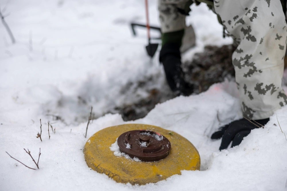 A Finnish Service Member with the Nylands Brigade, Finnish Navy, digs a hole for an inert mine during exercise Freezing Winds 23 (FW23) in Syndalen, Finland, Nov. 28, 2023. FW23 is a Finnish-led maritime exercise in which United States Marines assigned to Marine Rotational Force- Europe, and U.S. Navy Forces Europe take part; the exercise serves as a venue to increase Finnish Navy readiness, increase U.S., Finland, and NATO partners' interoperability in operational logistics, integrated fires, and amphibious operations within the Baltic Sea littorals. (U.S. Marine Corps photo by Lance Cpl. Jessica Mazzamuto) 